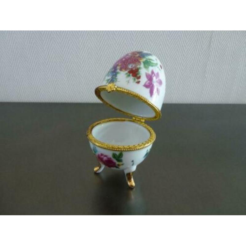Porselein ei met bloemen gedecoreerd, hoogte 10 cm.