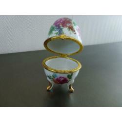 Porselein ei met bloemen gedecoreerd, hoogte 10 cm.